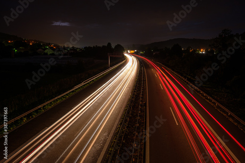 Red light trails of a car and truck on a motorway