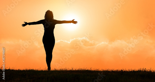 free and happy woman raises her arms at sunset. . Concept of power and determination.