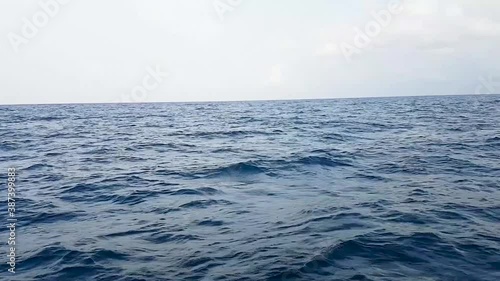 Rough blue sea. Big waves in the open ocean during a storm. Calm weather, cloudy overcast sky.