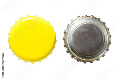 Both sides of a yellow metal bottle cap. One of the top side and one of the bottom side. Isolated on white background.
