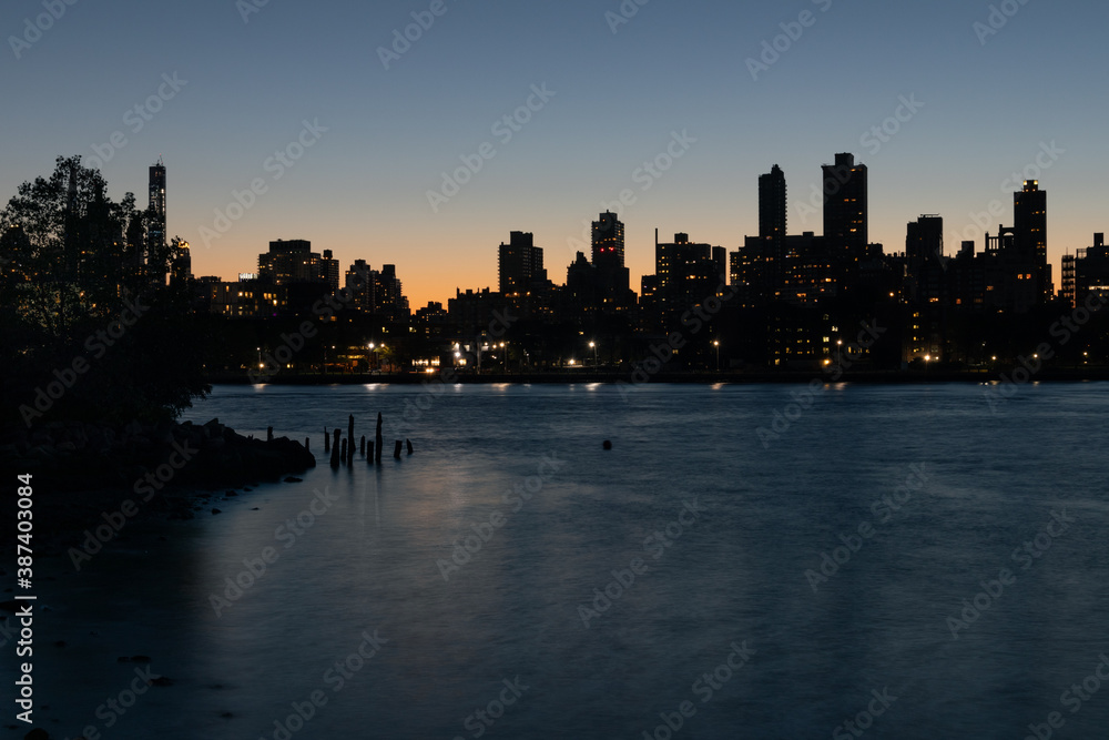 Silhouettes of Skyscrapers in the Upper East Side and Manhattan Skyline along the East River in New York City after a Sunset	