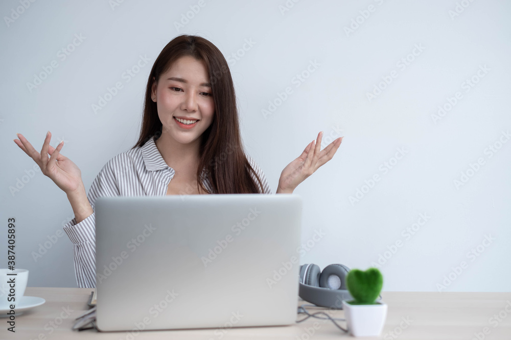 An Asian businesswoman talks to a team of co-workers about video conferencing plans, work at home ideas. An Asian businesswoman talks to a team of co-workers about video conferencing plans, work at home ideas.