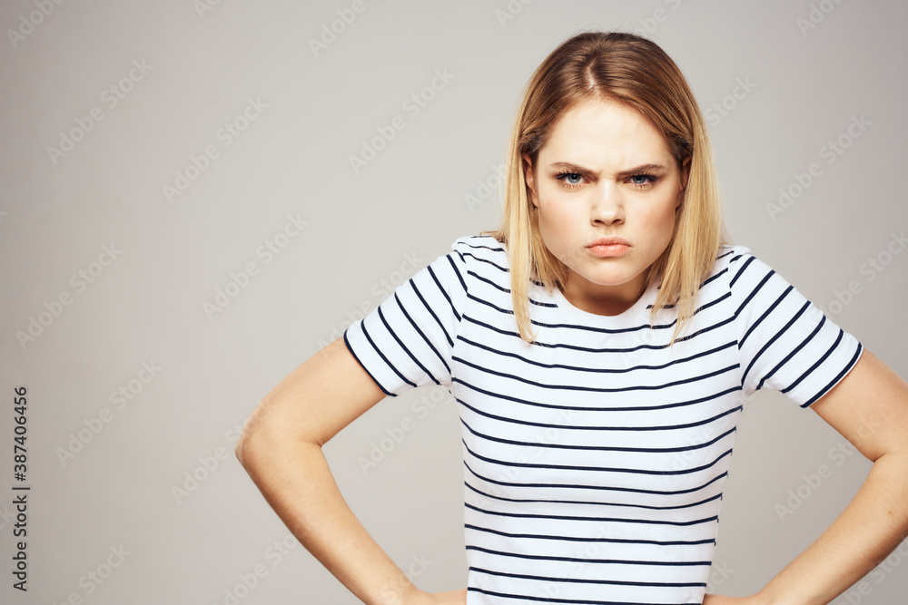 Emotional blonde woman in striped t-shirt lifestyle facial expression close-up Emotional blonde woman in striped t-shirt lifestyle facial expression close-up