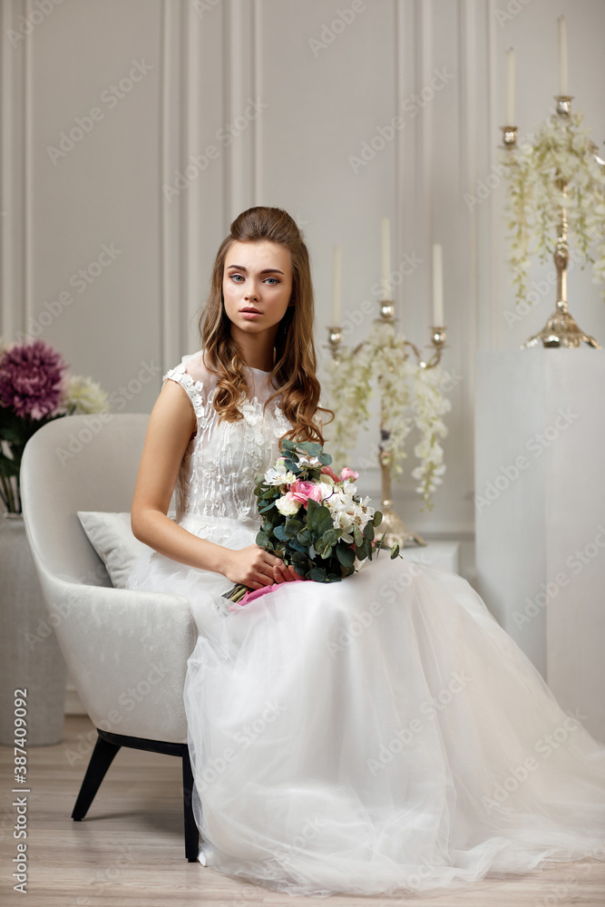beautiful tender young bride in a luxurious wedding dress with flower bouquet is waiting for the groom. beautiful tender young bride in a luxurious wedding dress with flower bouquet is waiting for the groom.
