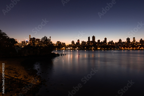 Upper East Side and Manhattan Skyline at Night along the East River in New York City seen from the Shore of Astoria Queens