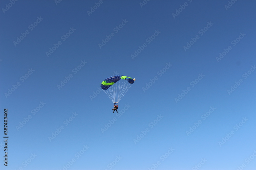 Person falling from the sky by parachute Person falling from the sky by parachute