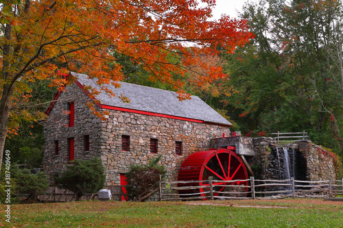 The Wayside Inn Grist Mill with water wheel and cascade water fall in Autumn.  photo