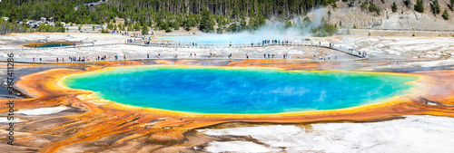 Grand Prismatic Spring panorama in Yellowstone National Park, Wyoming. Unidentifiable tourists enjoy the scenery on the boardwalk.