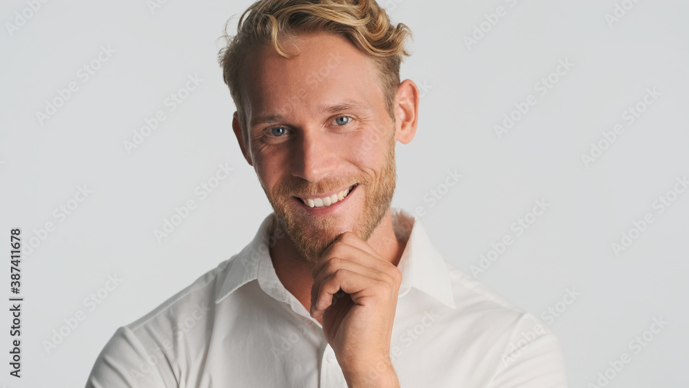 Successful smiling bearded man happily posing on camera over white background. Happy expression