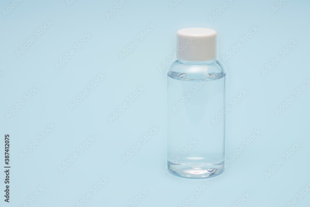 Bottle with disinfectant for hands from the virus Covid-19 on a blue background Bottle with disinfectant for hands from the virus Covid-19 on a blue background