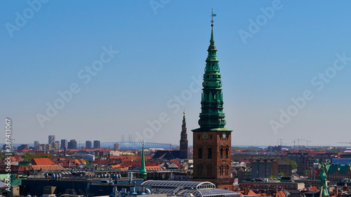 Beautiful panorama view of historic center of Copenhagen, Denmark including steeple of churches (e.g. Vor Frelsers Kirke) and Øresund Bridge (road connection to Sweden) on the horizon.