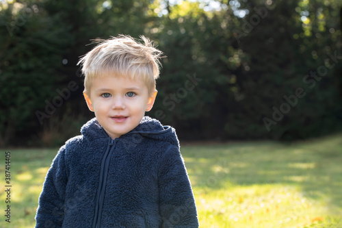 little boy outside with a blue fuzzy coat photo