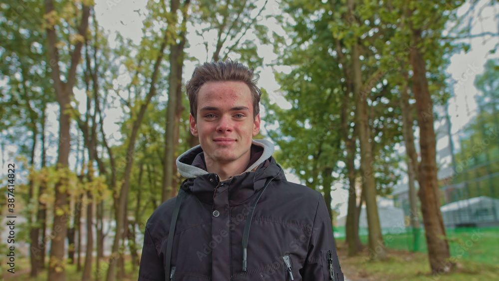 Teenage boy smiling outdoors. Young boy smiling on a road in the woods. Portrait of a happy handsome young boy looking into the camera. Teenage boy smiling outdoors. Young boy smiling on a road in the woods. Portrait of a happy handsome young boy looking into the camera.