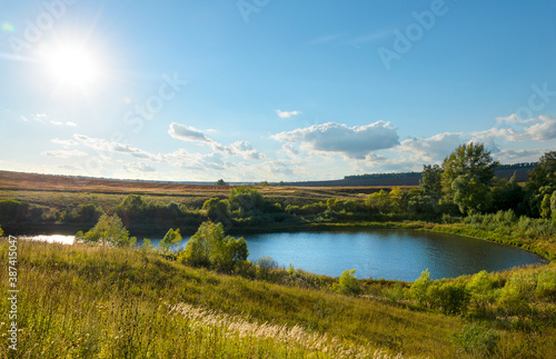 Sunny landscape with lake and blue sky