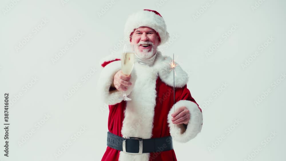 joyful santa claus holding champagne glass and sparkler isolated on white joyful santa claus holding champagne glass and sparkler isolated on white
