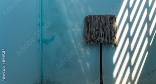 Old dirty swab cloth on blue wall with light and shadow
