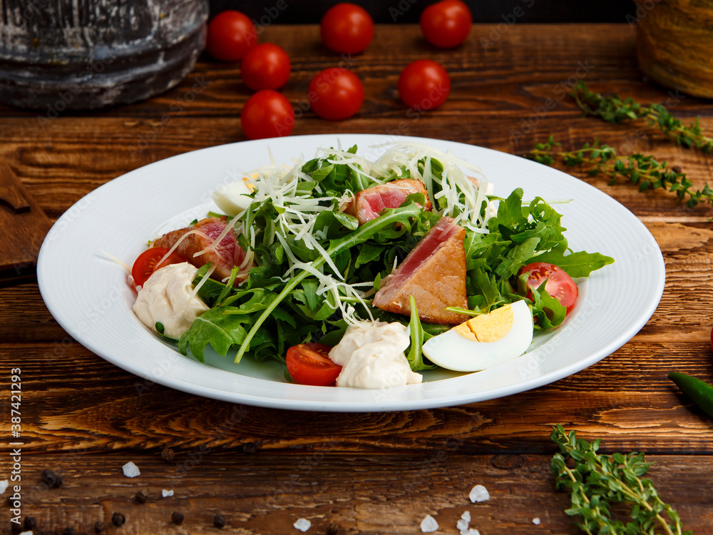 salad with tuna, egg and herbs in a plate on a wooden background salad with tuna, egg and herbs in a plate on a wooden background
