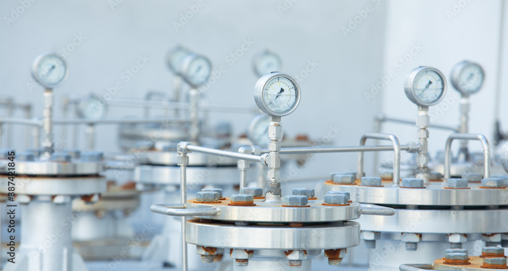Close up and front view shot with copy space, blurred background and selective focus shot of cylinder metal tanks with pressure gauges shows safety environment equipment in petrochemical industry Close up and front view shot with copy space, blurred background and selective focus shot of cylinder metal tanks with pressure gauges shows safety environment equipment in petrochemical industry