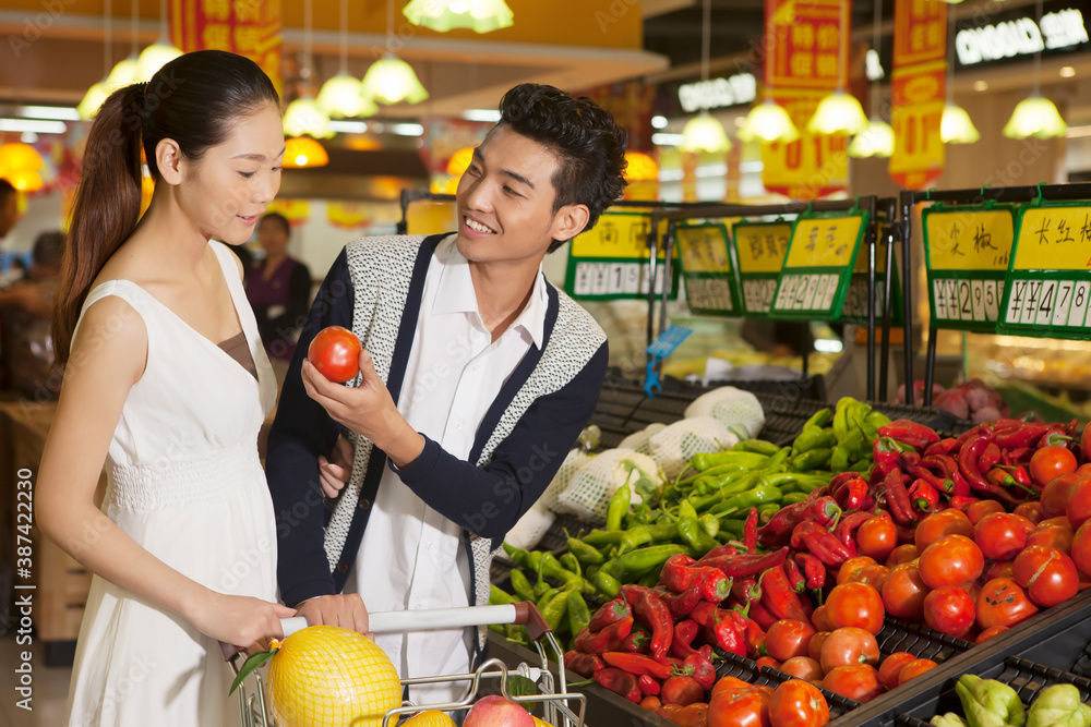 Fototapeta premium A young couple in the supermarket shopping