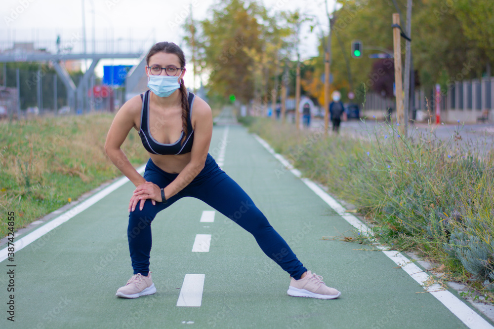 Vista de una joven mujer caucásica con una máscara de ejercicio en la calle Vista de una joven mujer caucásica con una máscara de ejercicio en la calle