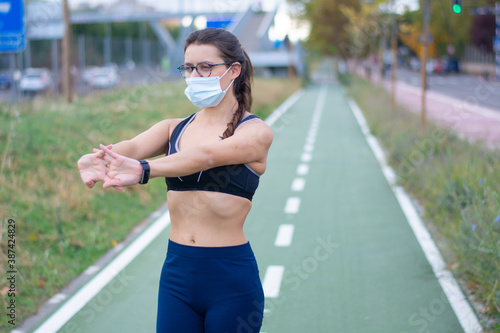 Vista de una joven mujer caucásica con una máscara de ejercicio en la calle