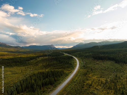 Beautiful View of Scenic Road surrounded by Forest and Mountains at Sunset. Aerial Drone Shot in Canadian Nature. Taken by Alaska Highway, Southern Yukon, Canada. © edb3_16