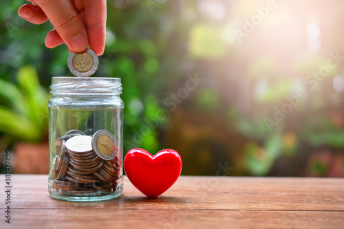 Fényképezés putting coins on bottle glass for concept donation and philanthropy