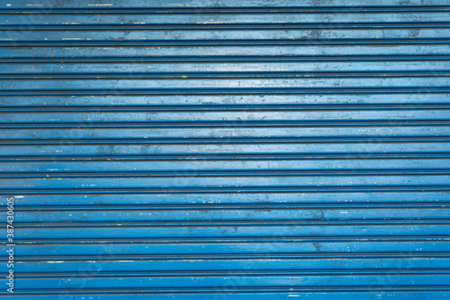 Blue metal roll-up door old texture background.
