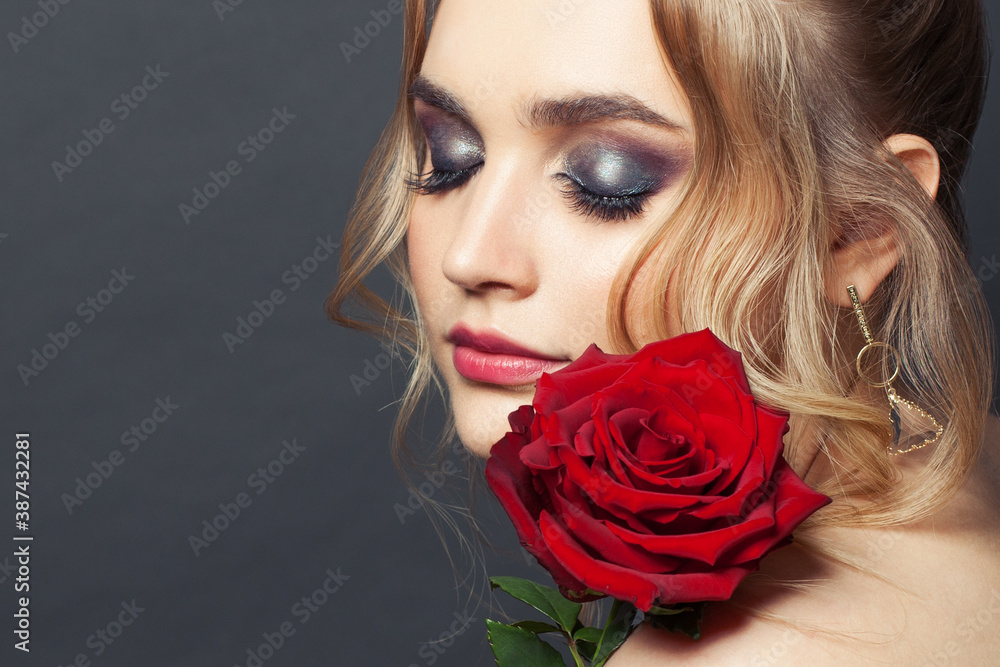 Beautiful woman face with makeup and red rose flower Beautiful woman face with makeup and red rose flower