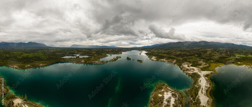 Fototapeta premium Beautiful Panoramic View of Scenic Lake, Islands and Forest in Canadian Nature. Aerial Done Shot taken near Klondike Highway. Lewes Lake, South of Whitehorse, Yukon, Canada.