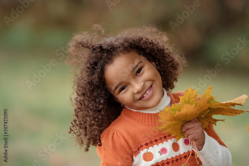 Adorable little girl outdoors at beautiful autumn day photo