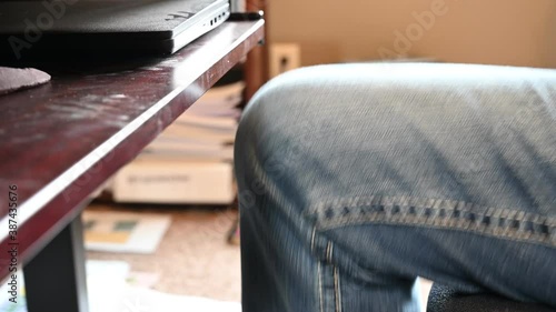 knee bouncing repeatedly as a person nervously waits while working in a home office