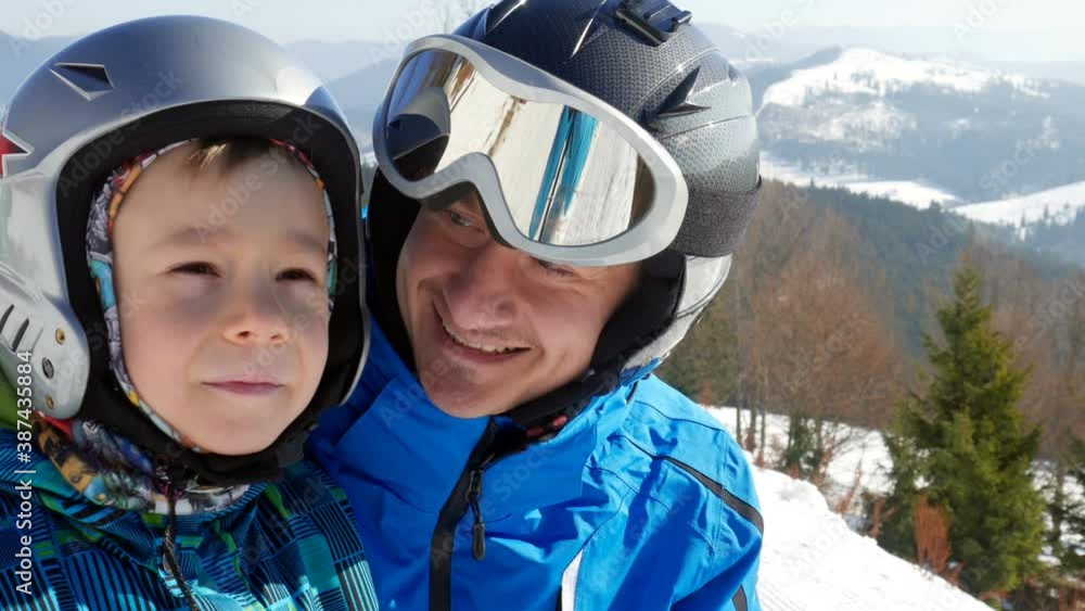 Attentive father and son on the ski resort in mountains. Happy family concept while traveling, relax and active sports outdoors. Attentive father and son on the ski resort in mountains. Happy family concept while traveling, relax and active sports outdoors.