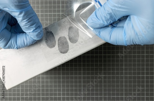 scientific police using fingerprint instant lifters, adhesive film for catching photo