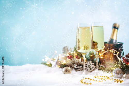 Champagne glasses and christmas decor on blue sparkling holiday background