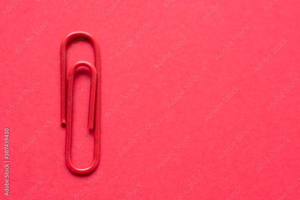 Red paper clip over a cherry red background, with copy space at the right side of the photo Red paper clip over a cherry red background, with copy space at the right side of the photo
