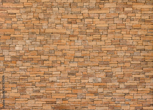 background and texture of yellow decorative stone wall surface.