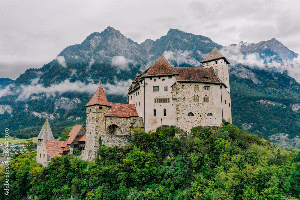 Castle at Vaduz ancient stone building with mountain background and fog