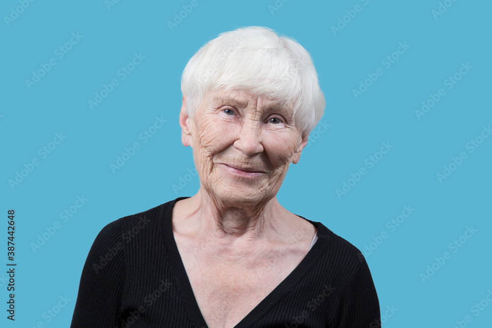 Portrait of an elderly woman on a blue background. Portrait of an elderly woman on a blue background.