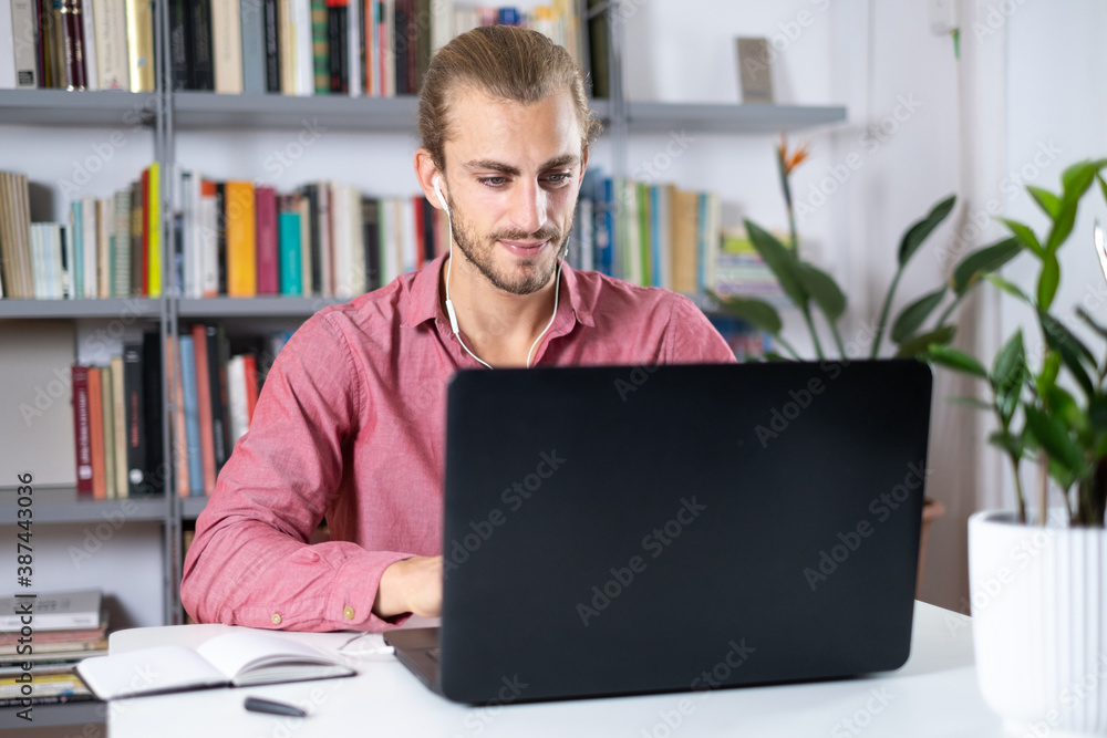 young man sitting at the table at home working young man sitting at the table at home working