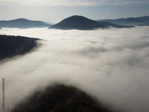 Foggy valley with mountains and blue clear sky