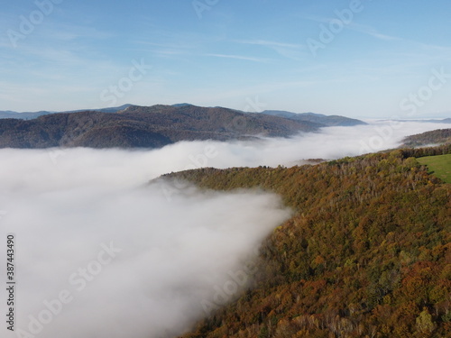 Foggy valley with mountains and blue clear sky