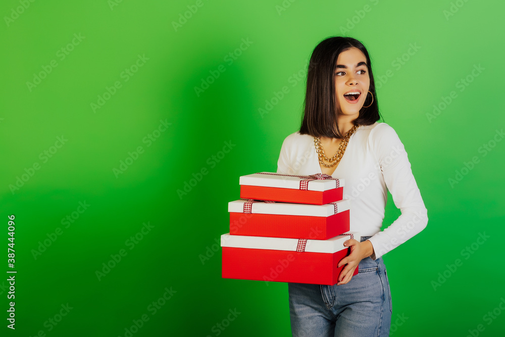 Charming smiling happy girl holding a lot of gift boxes, isolated on green background. Christmas, New Year, birthday and holidays concept. Free space for text. Charming smiling happy girl holding a lot of gift boxes, isolated on green background. Christmas, New Year, birthday and holidays concept. Free space for text.
