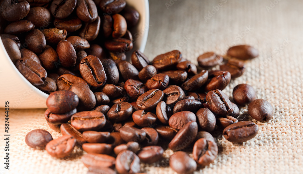 roasted coffee beans, (selective focus on coffee beans), with raffia sack roasted coffee beans, (selective focus on coffee beans), with raffia sack