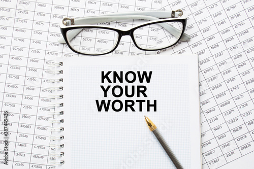 text KNOW YOUR WORTH in a magnifying glass  office concept  business concept  Finance