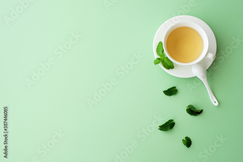 herbal mint tea in a white cup on a light green background