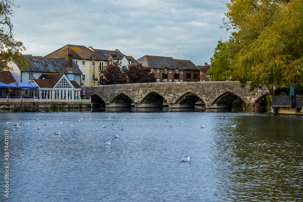 A view across the River Avon close to the ancient bridge at Fordingbridge, UK at dusk in Autumn