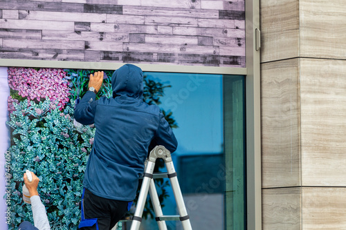 Workers installing window film outdoor
