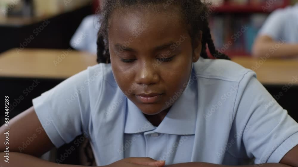 Young black girl looks up at the camera and sighs. Student with depression. Young black girl looks up at the camera and sighs. Student with depression.