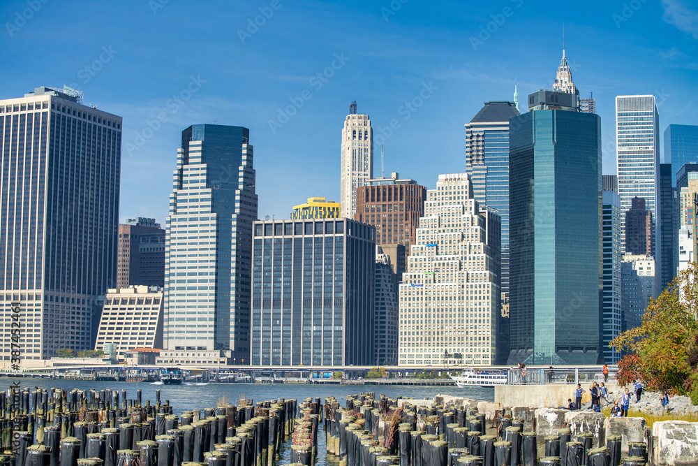 Obraz premium NEW YORK CITY - OCTOBER 2015: View of Downtown Manhattan Skyscrapers from Brooklyn Bridge Park on a beautiful autumn day